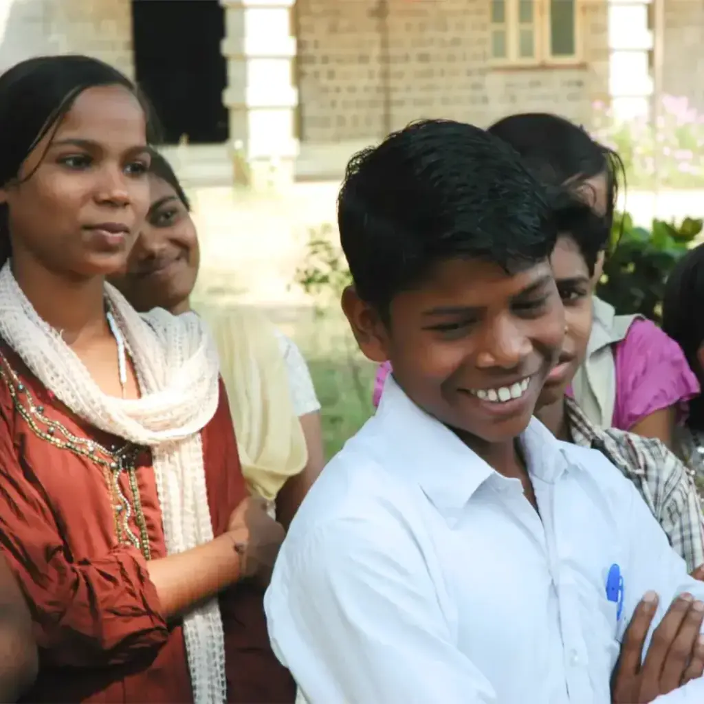 Das Bild zeigt fünf Kinder, die in einer Gruppe und hintereinander stehen und lächeln.